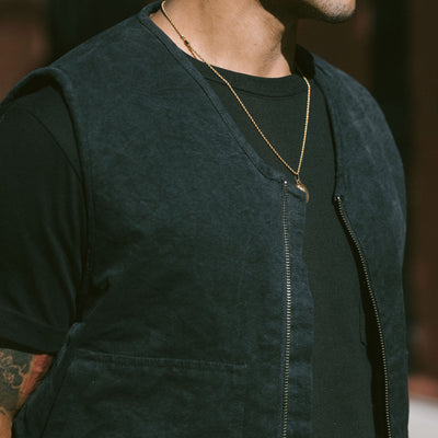 An image of a black work vest worn over a black tshirt.