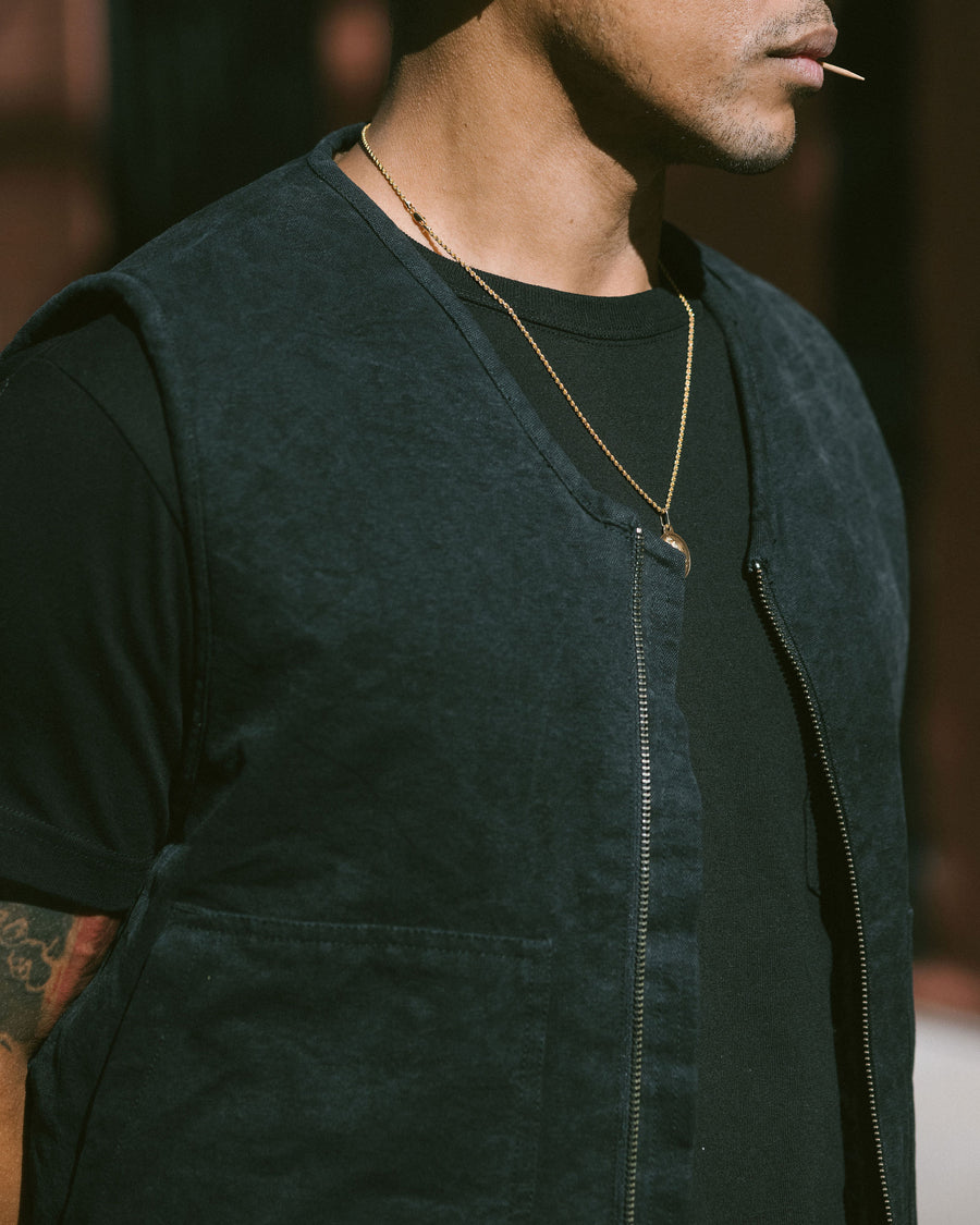 An image of a black work vest worn over a black tshirt.