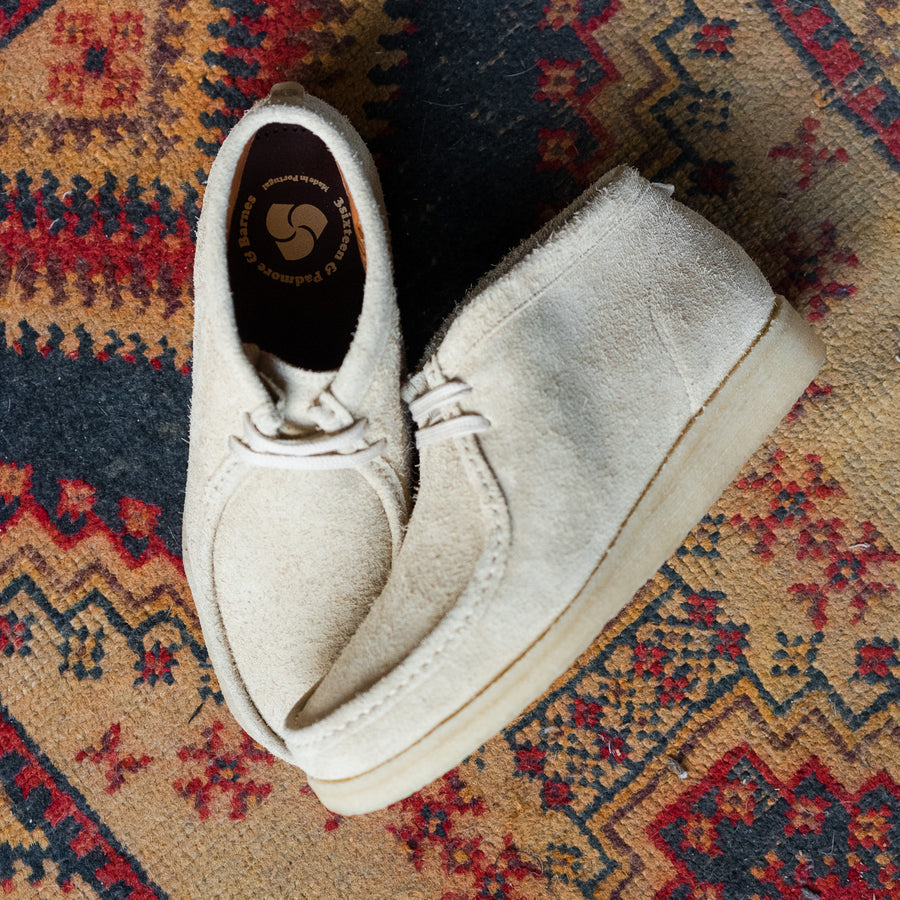 A pair of light tan shoes on a rug.