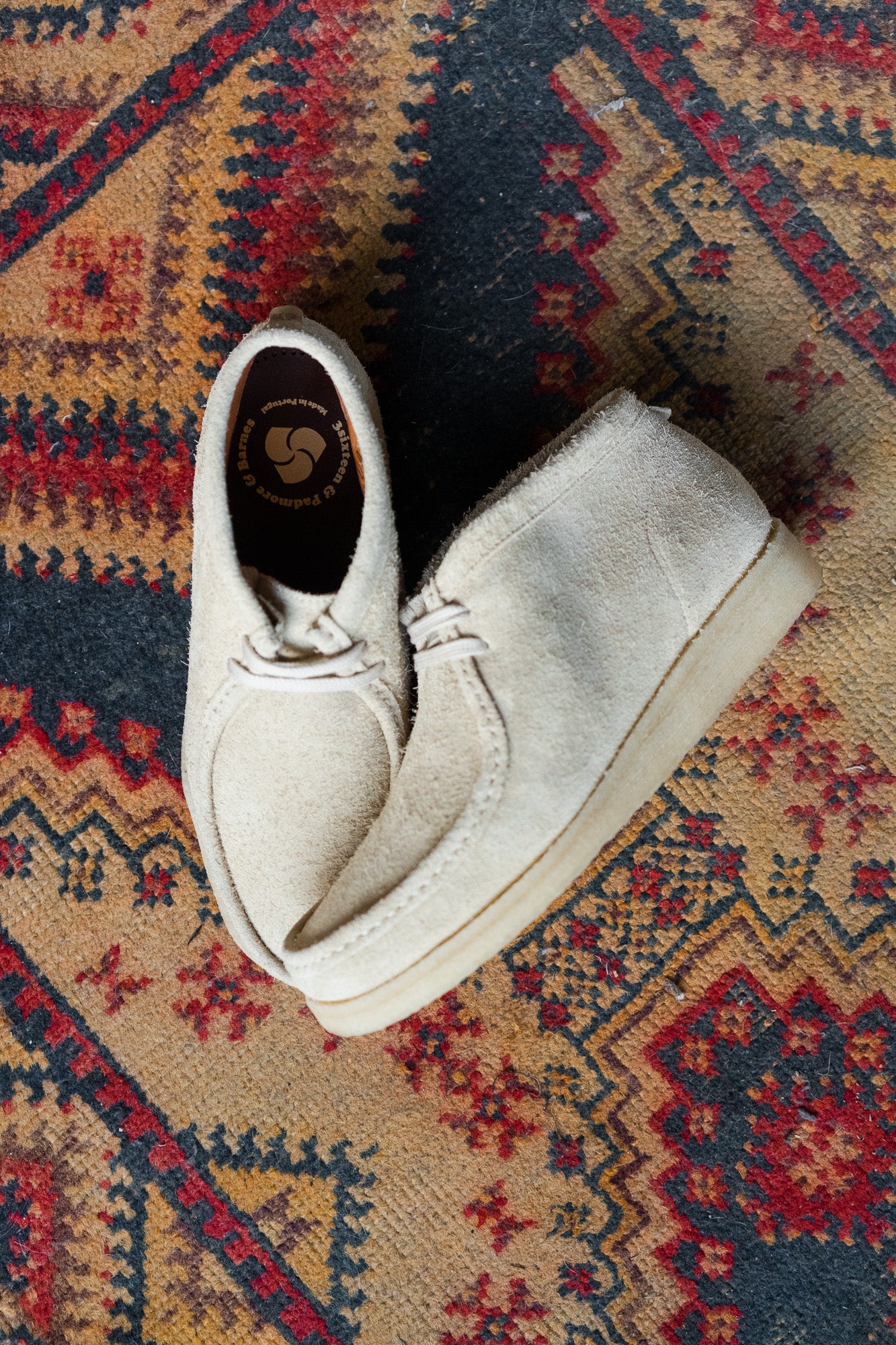 A pair of light tan shoes on a rug.