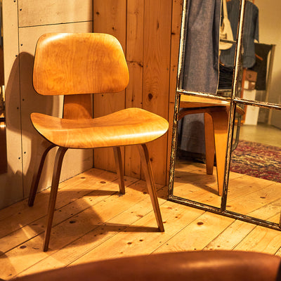An eames chair in a mirrored dressing room.
