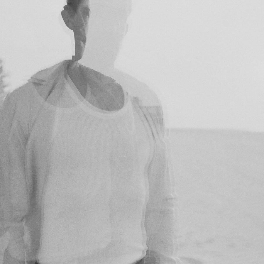 A blurry shot of a man in a button down shirt.