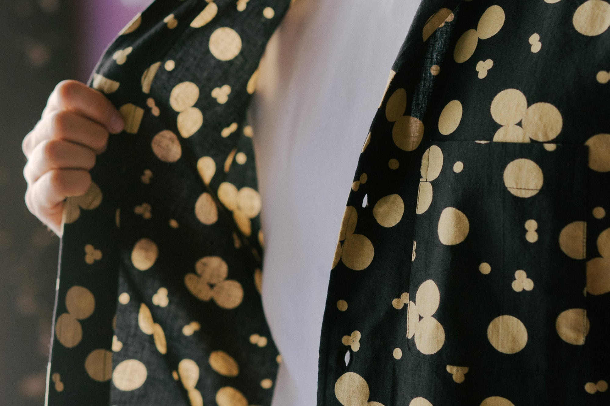 A close up image of a black shirt with a cream pattern printed on.