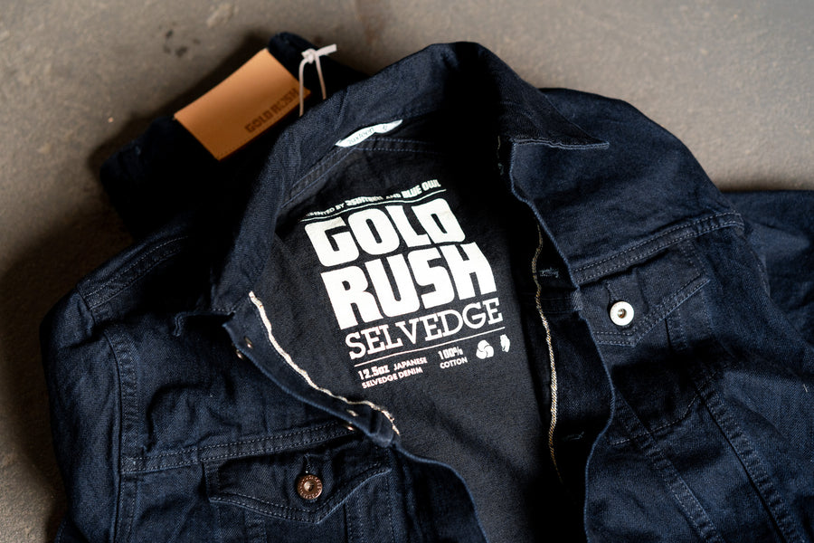 A dark blue denim jacket lies open on the floor.