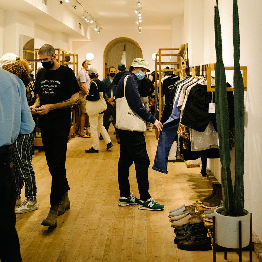 People gather inside a shop and look at clothes.