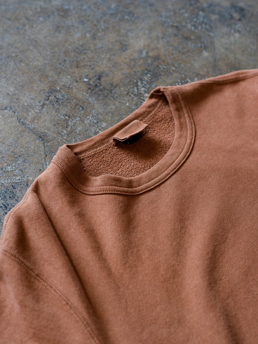 A close up view of the clove crewneck sweatshirt lying on the ground.