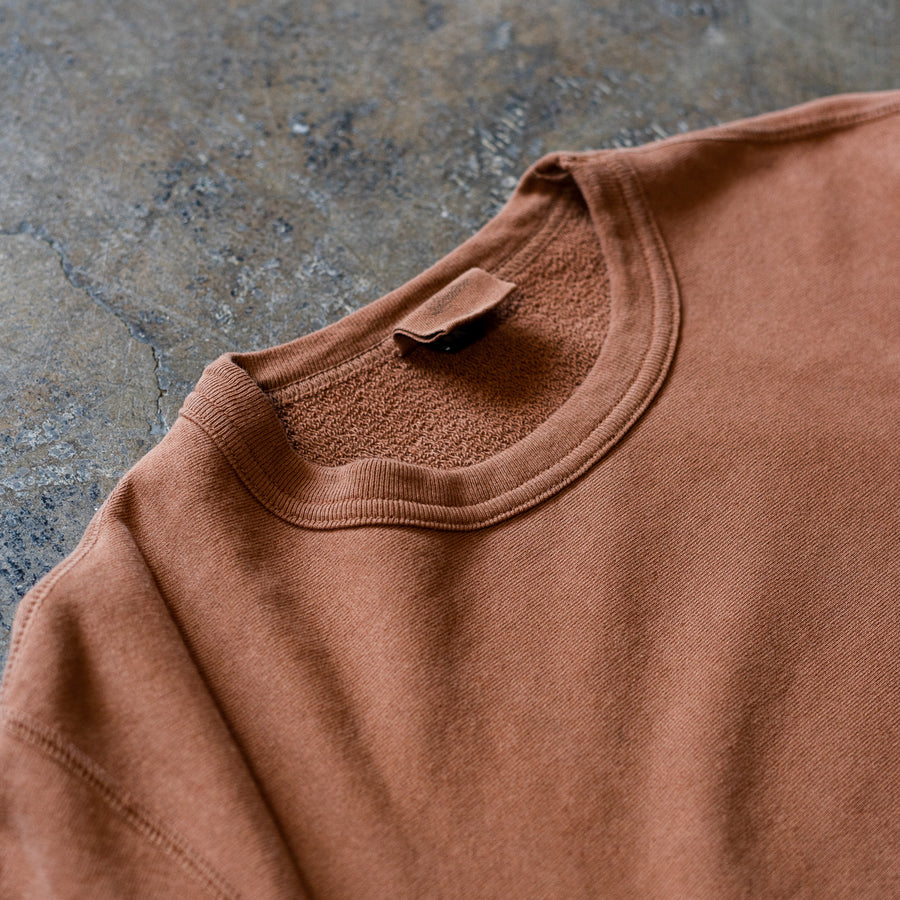 A close up view of the clove crewneck sweatshirt lying on the ground.