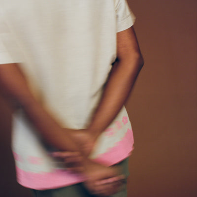 A blurry photo of a shirt with hands crossed behind the back.