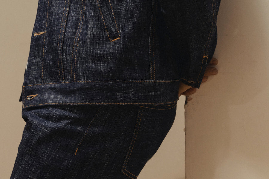 A close up image of the hem of a denim jacket.