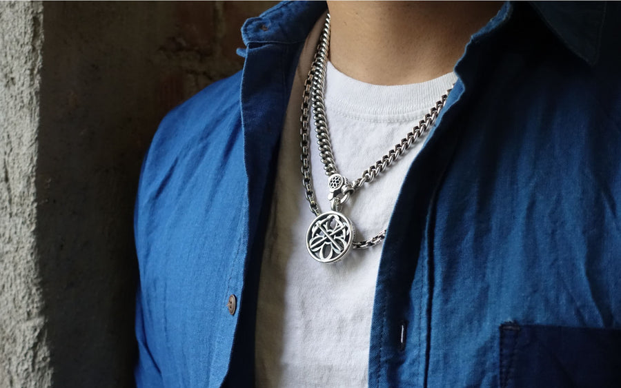 The model wears a Good Art sterling silver pendant around the neck on a chain.