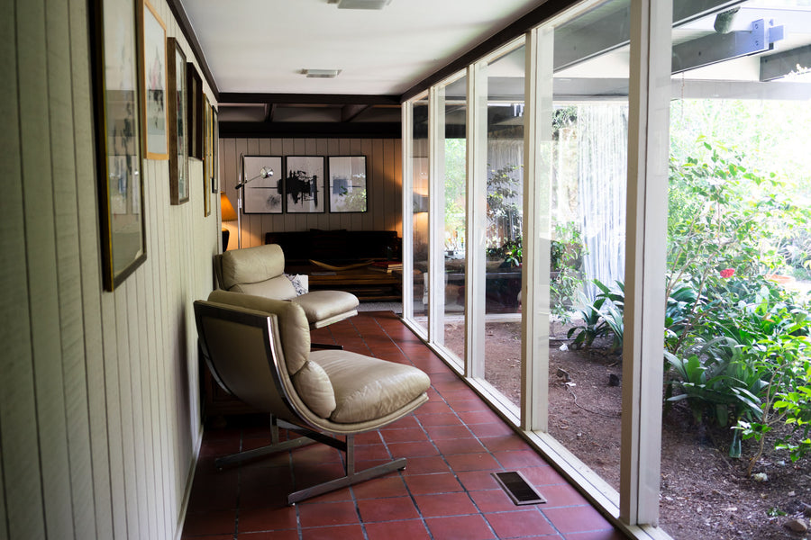 A hallway lined with floor-to-ceiling glass windows allows natural light to flood the space.