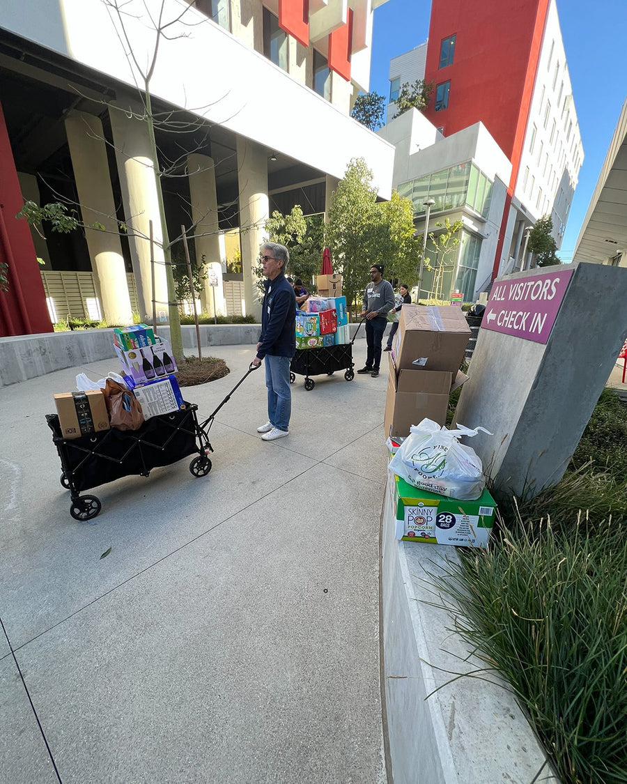People lined up to give donations in wheelbarrows.