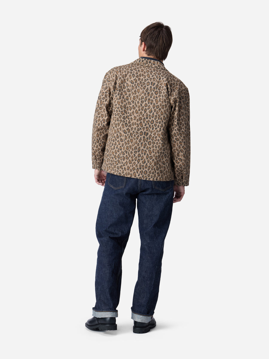 Person wearing a leopard print jacket and blue jeans on a white background