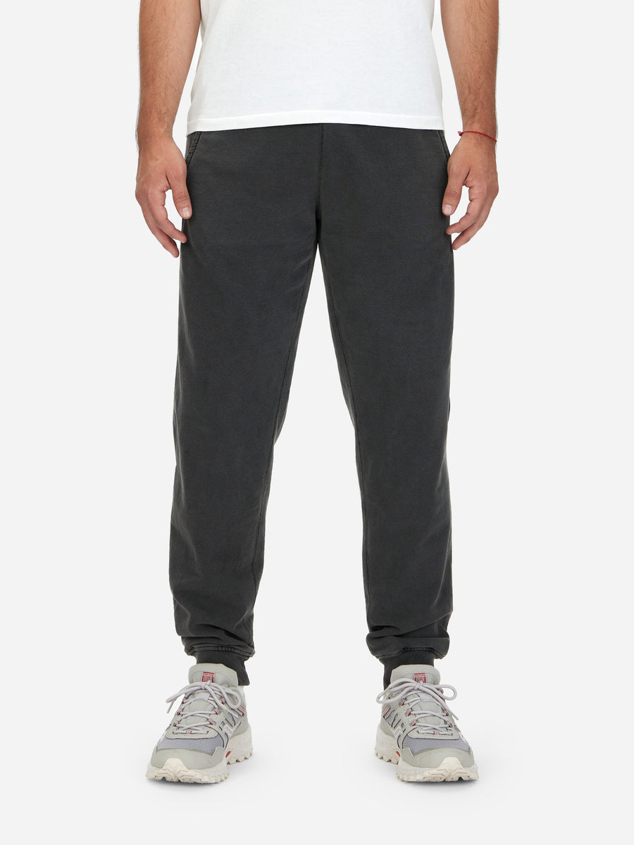 A pair of gray French terry sweatpants with rib side gussets, worn with a white T-shirt and gray sneakers.