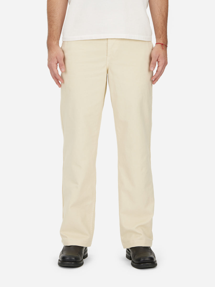 A pair of beige, wide leg fit, high rise work pants with corozo buttons, made from chino twill fabric.