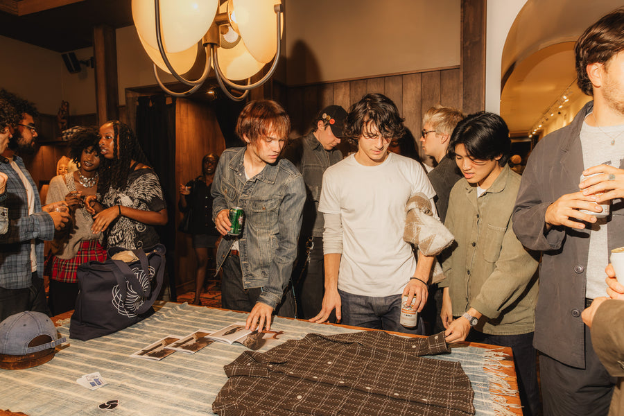 A few guys examining a shirt on a table.