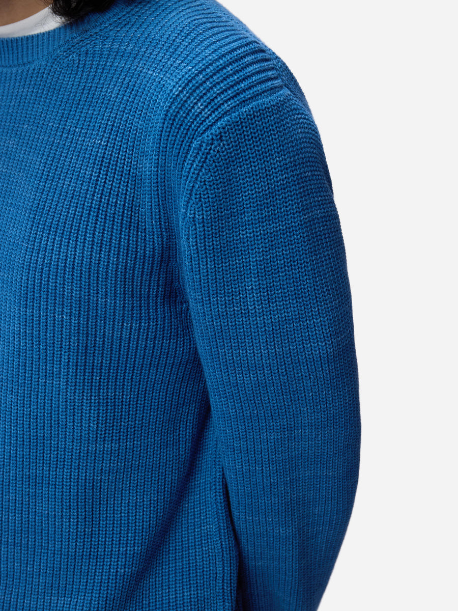 Close-up of a blue ribbed sweater on a white background