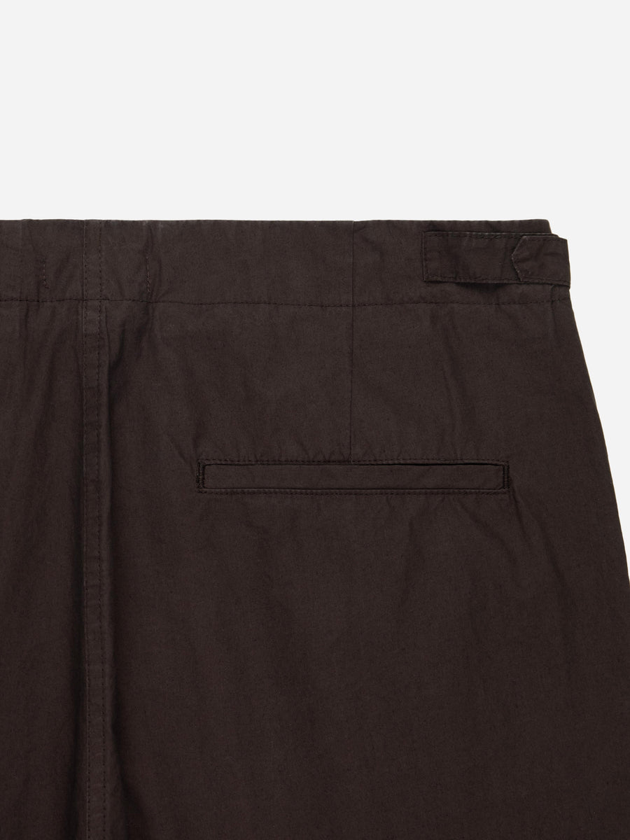 Close-up of dark brown pants with a pocket on a white background