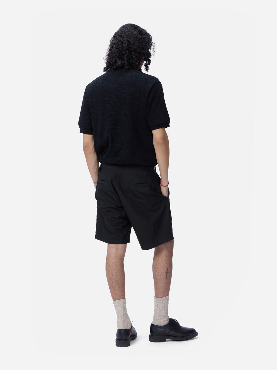 Person wearing a black t-shirt and shorts on a white background