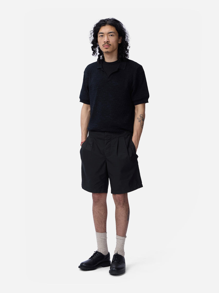 Person wearing a black shirt and shorts on a white background