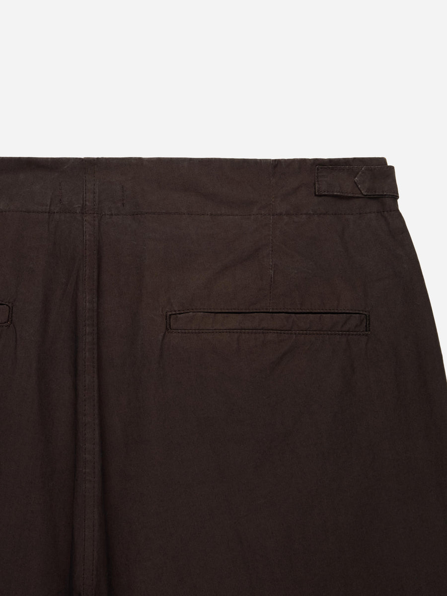 Close-up of dark brown pants with a pocket on a white background