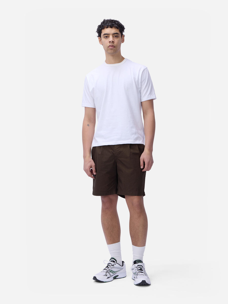 Person wearing a white t-shirt and brown shorts on a white background