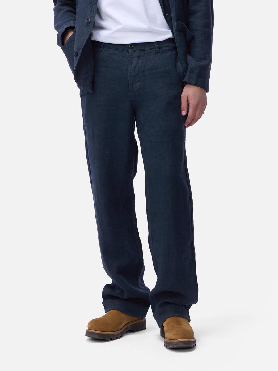 Person wearing dark blue pants and brown shoes on a white background