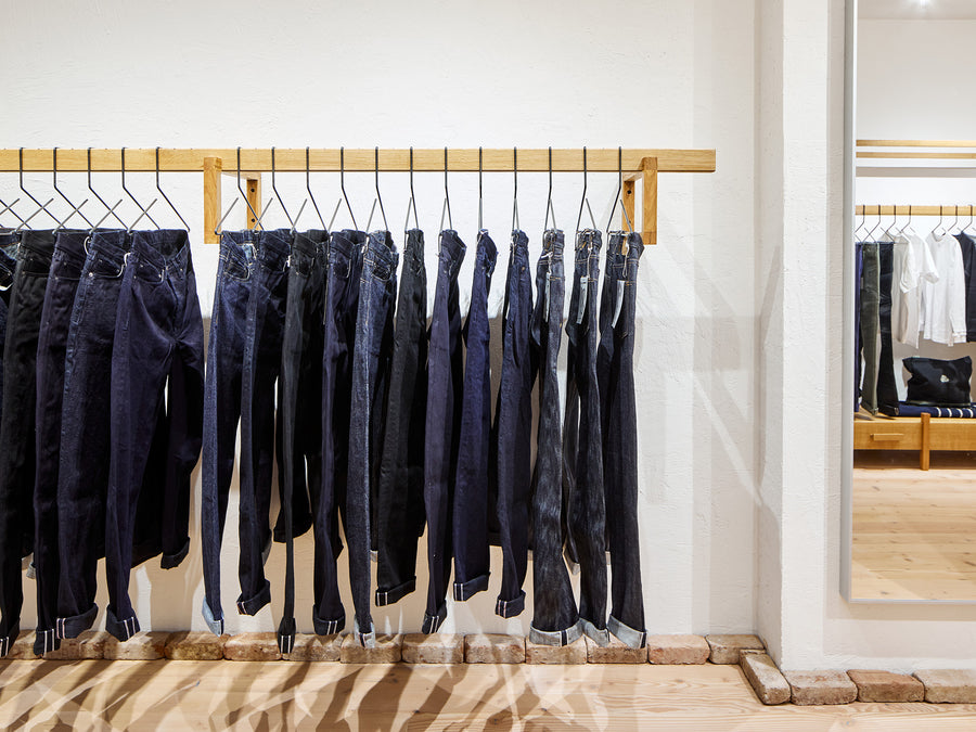 A wooden bar with a rack full of jeans.