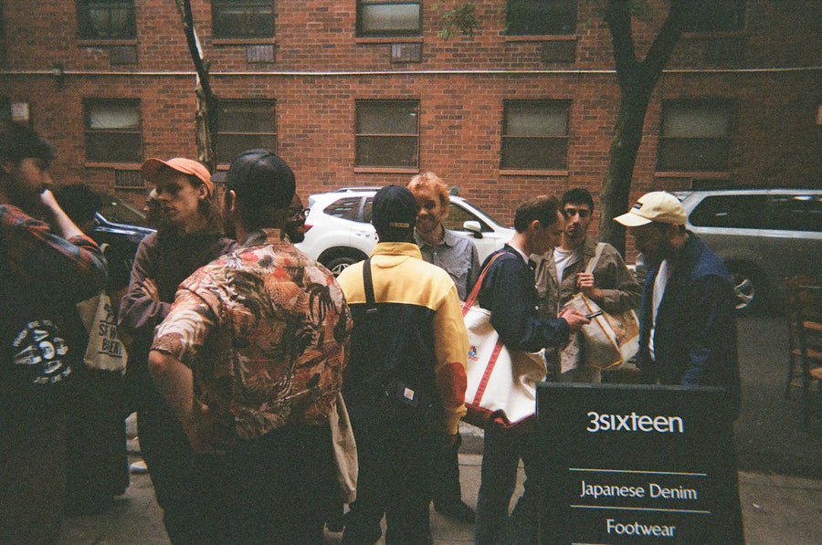 A group of young men hang out on the sidewalk in downtown NYC.