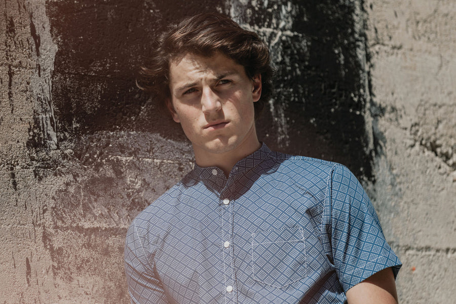 Closeup of man wearing navy-colored short sleeve shirt.