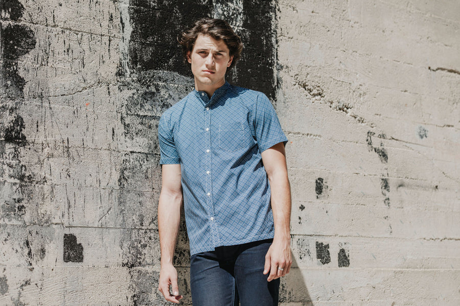 Man wearing short sleeve band collar shirt.