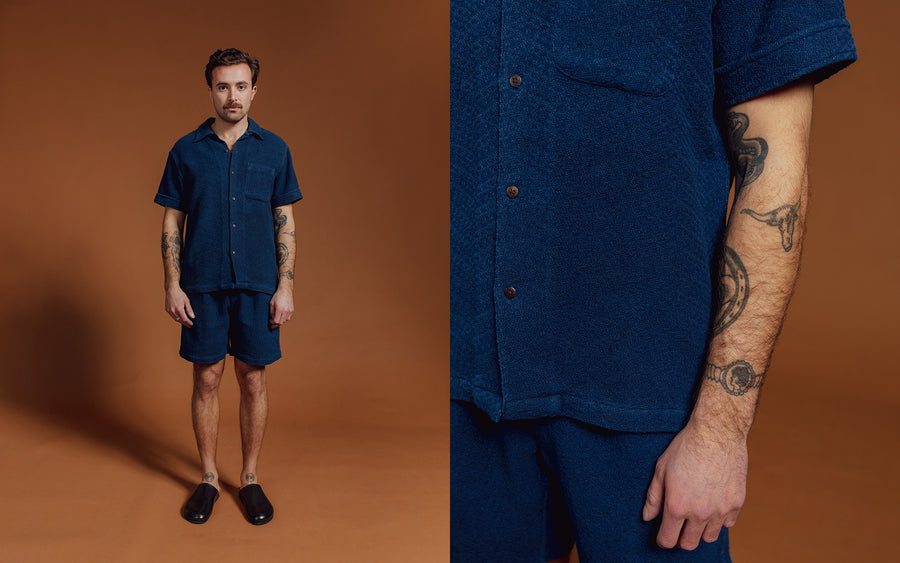 A man in blue shirt and shorts.