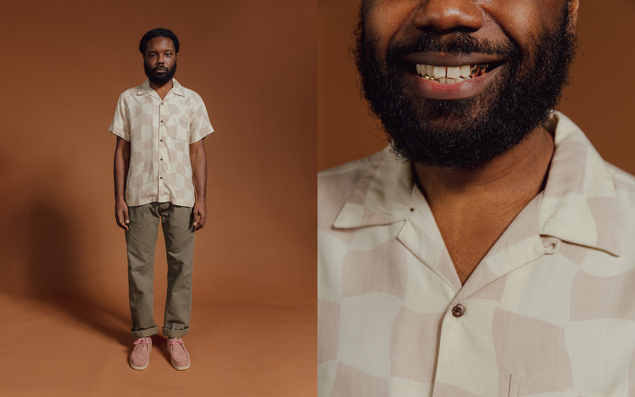 A man in a tan checkerboard shirt and olive pants.