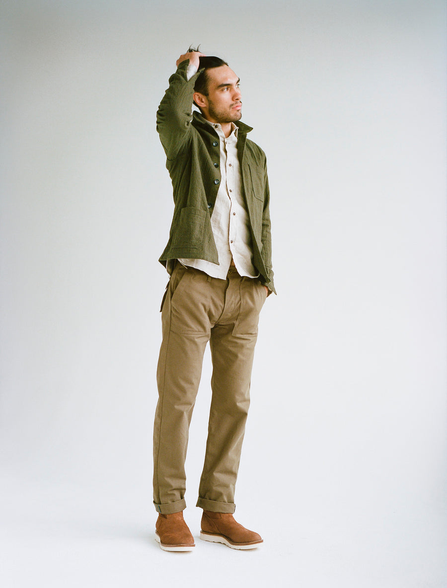Model wearing olive jacket, tan shirt, and tan pants.