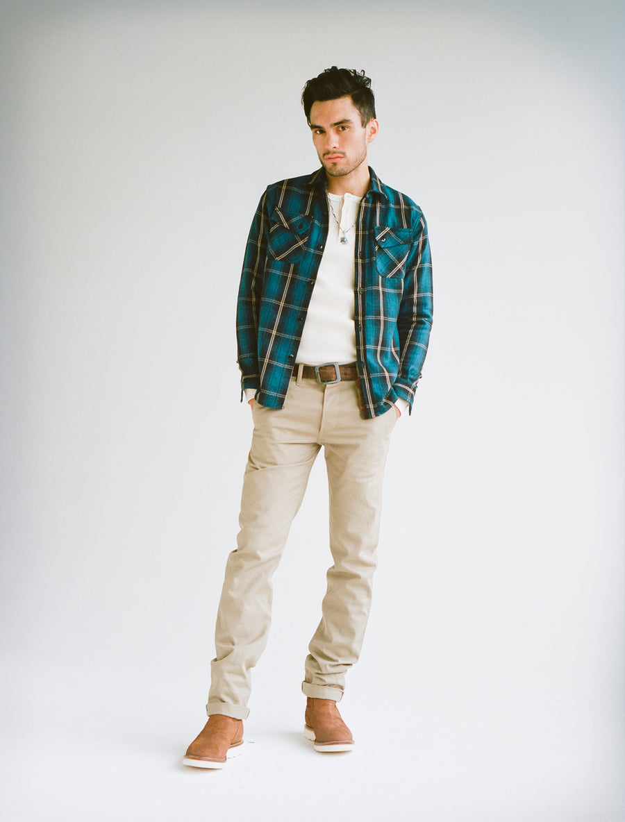 Model wearing blue flannel shirt, natural thermal, and tan chinos.