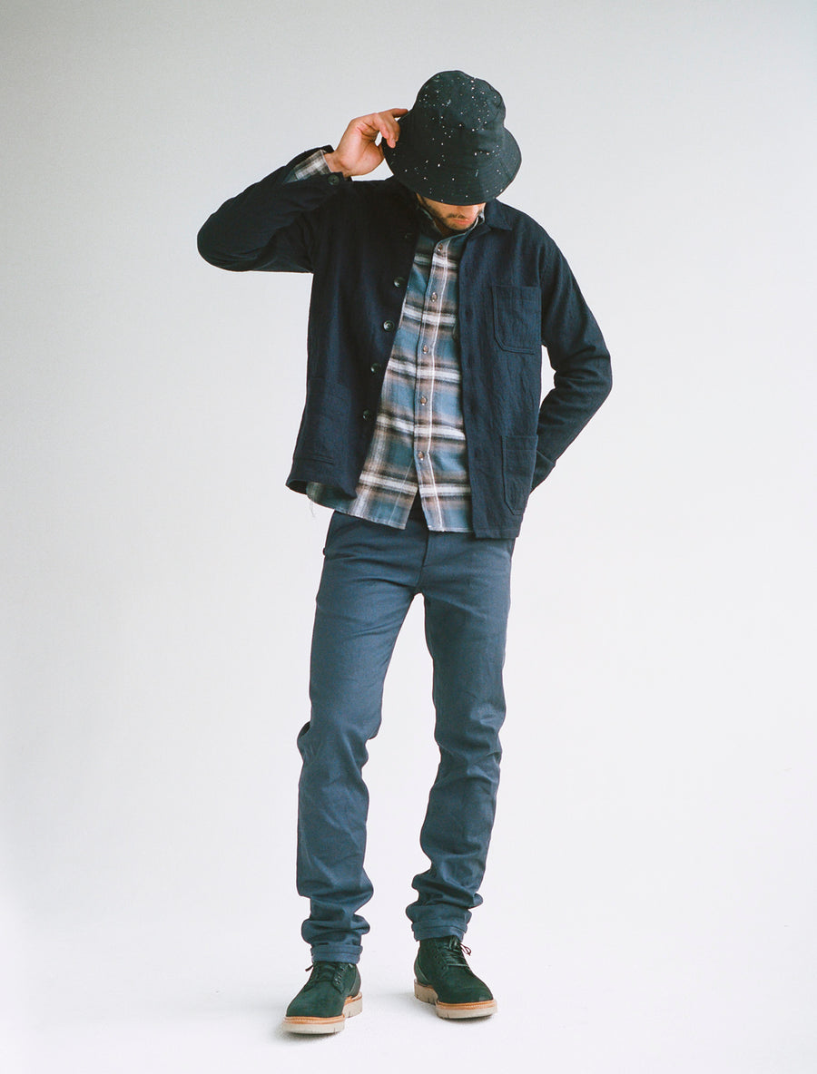 Model wearing navy bucket hat, navy wool jacket, blue flannel, and navy chinos.