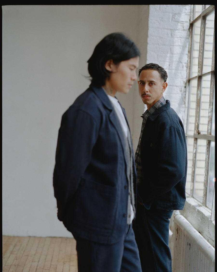 Two guys in navy outfits pose for the camera