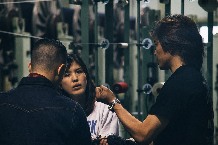 Three people talk at Kuroki Mills in Okayama, Japan.