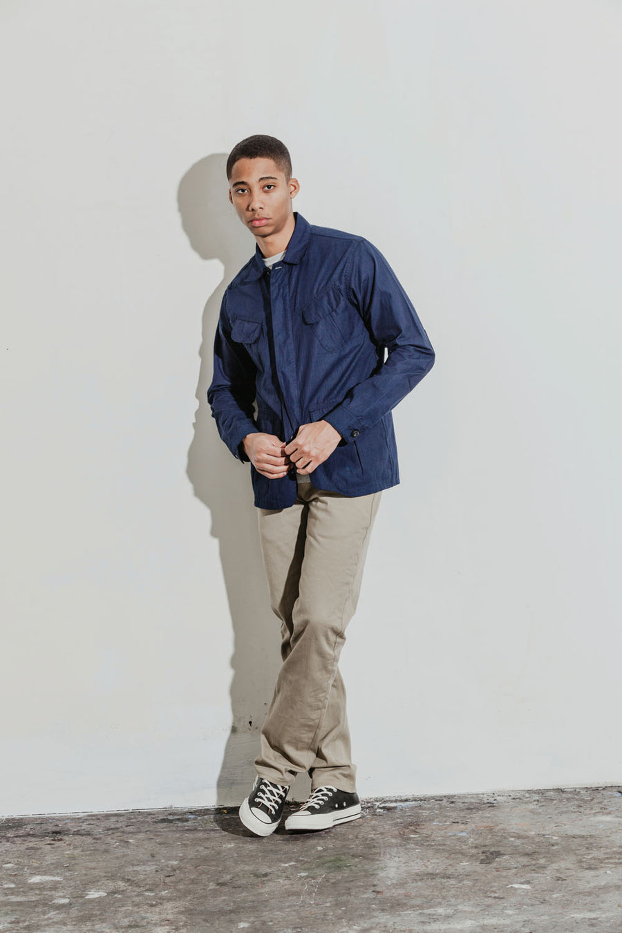 Model wears an indigo jacket coupled with tan khakis.