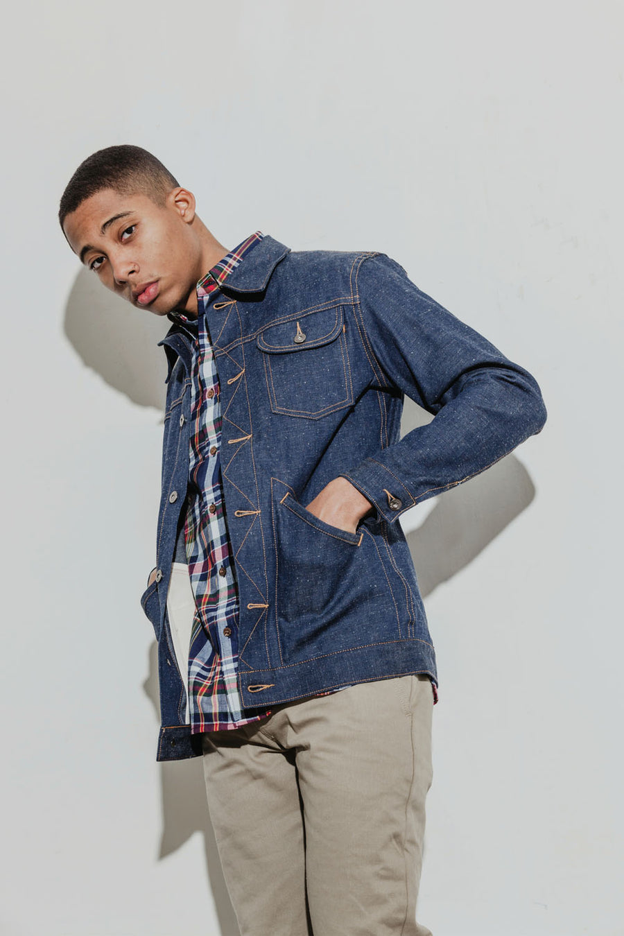 Model wears a plaid madras shirt under a Ranch Jacket with tan khakis.