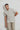 Model wears a tan aztec patterned popover shirt and tan khaki pants..