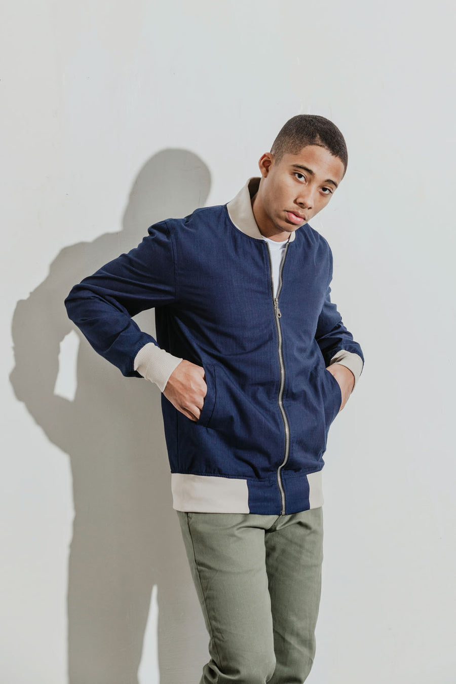 Model wears a navy bomber jacket.