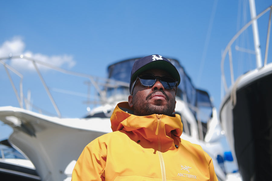 A portrait of Chris standing by some boats.