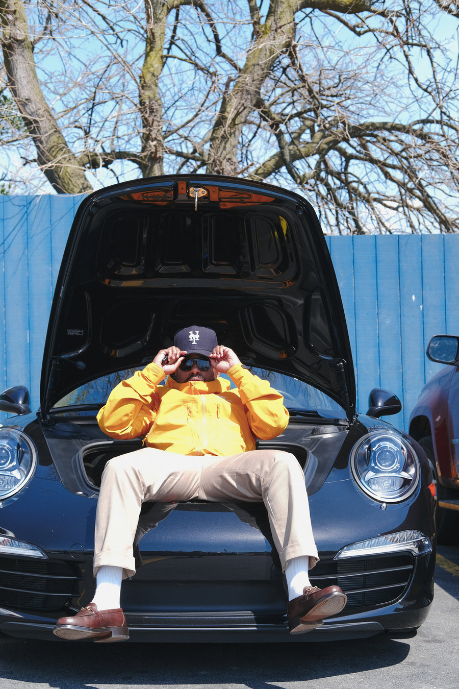 Chris sitting in the front trunk of his Porche.