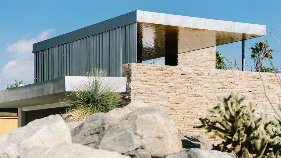 A stunning mid-century ranch home sits upon a hill.