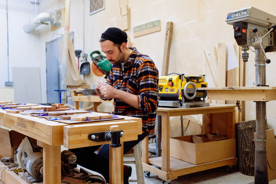 Man assembling wood pieces on table.