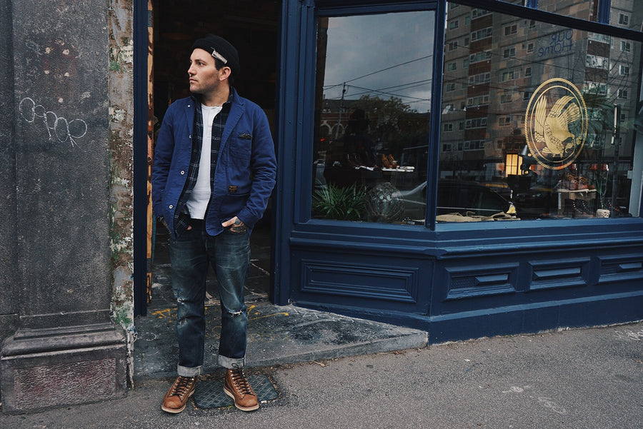 Man posing at front door of shop.