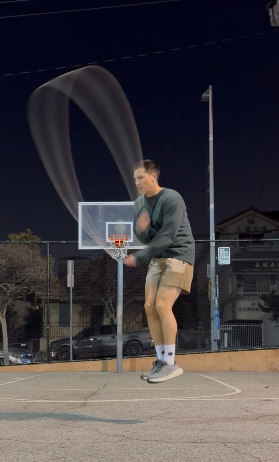 A man jumping rope at night.