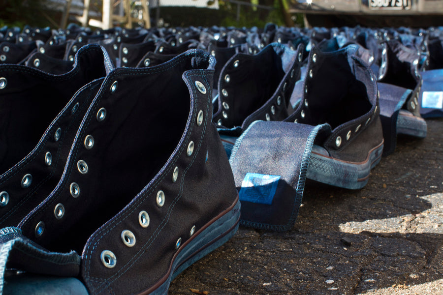 One hundred pairs of indigo dyed Converse sneakers lay out to dry.