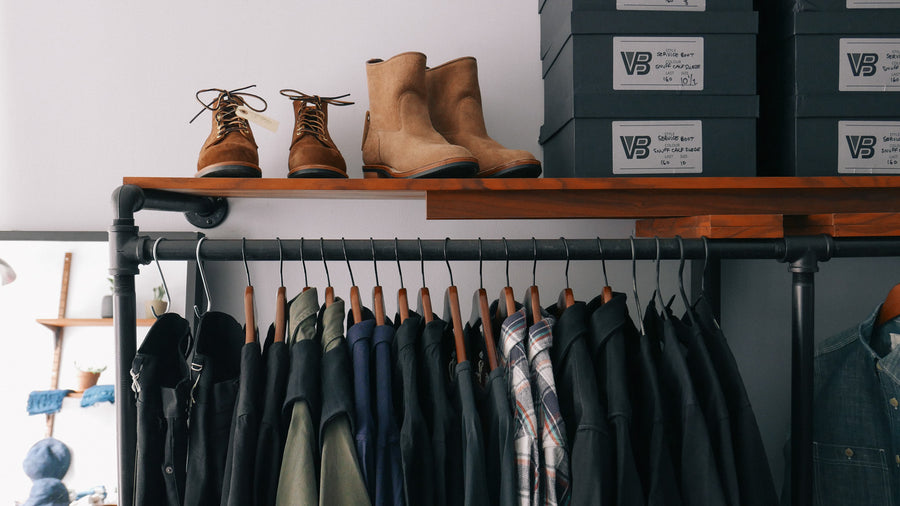 Clothing rack showcasing various clothing and boots.